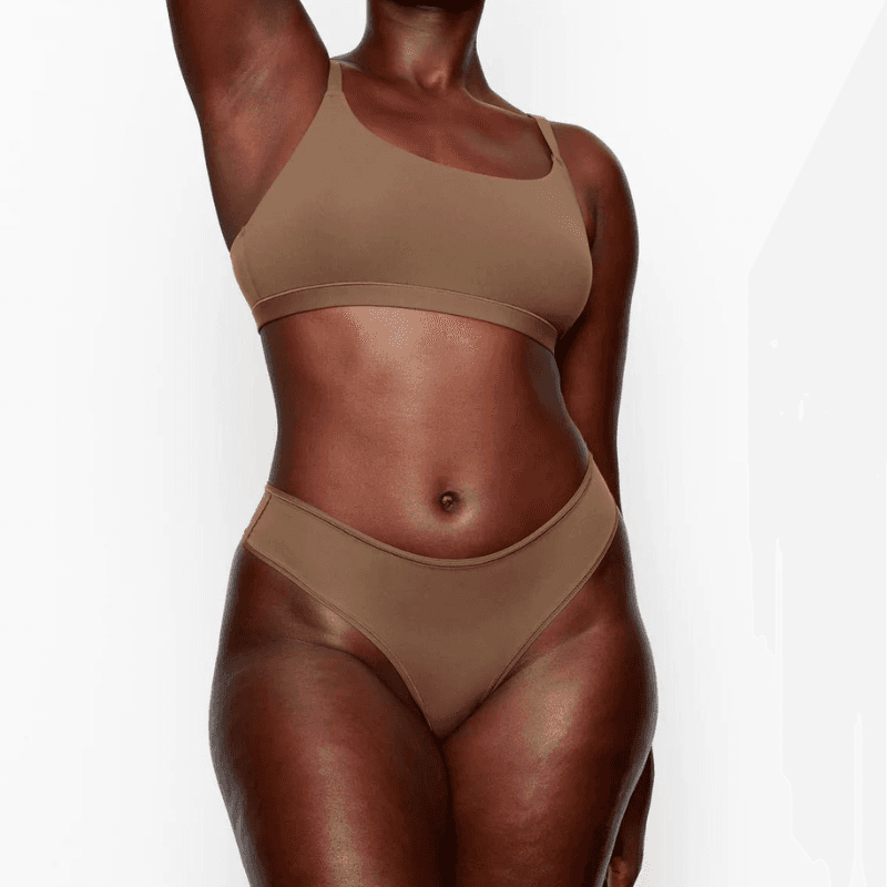 Foto de Back view of slim tanned woman in nude color underwear